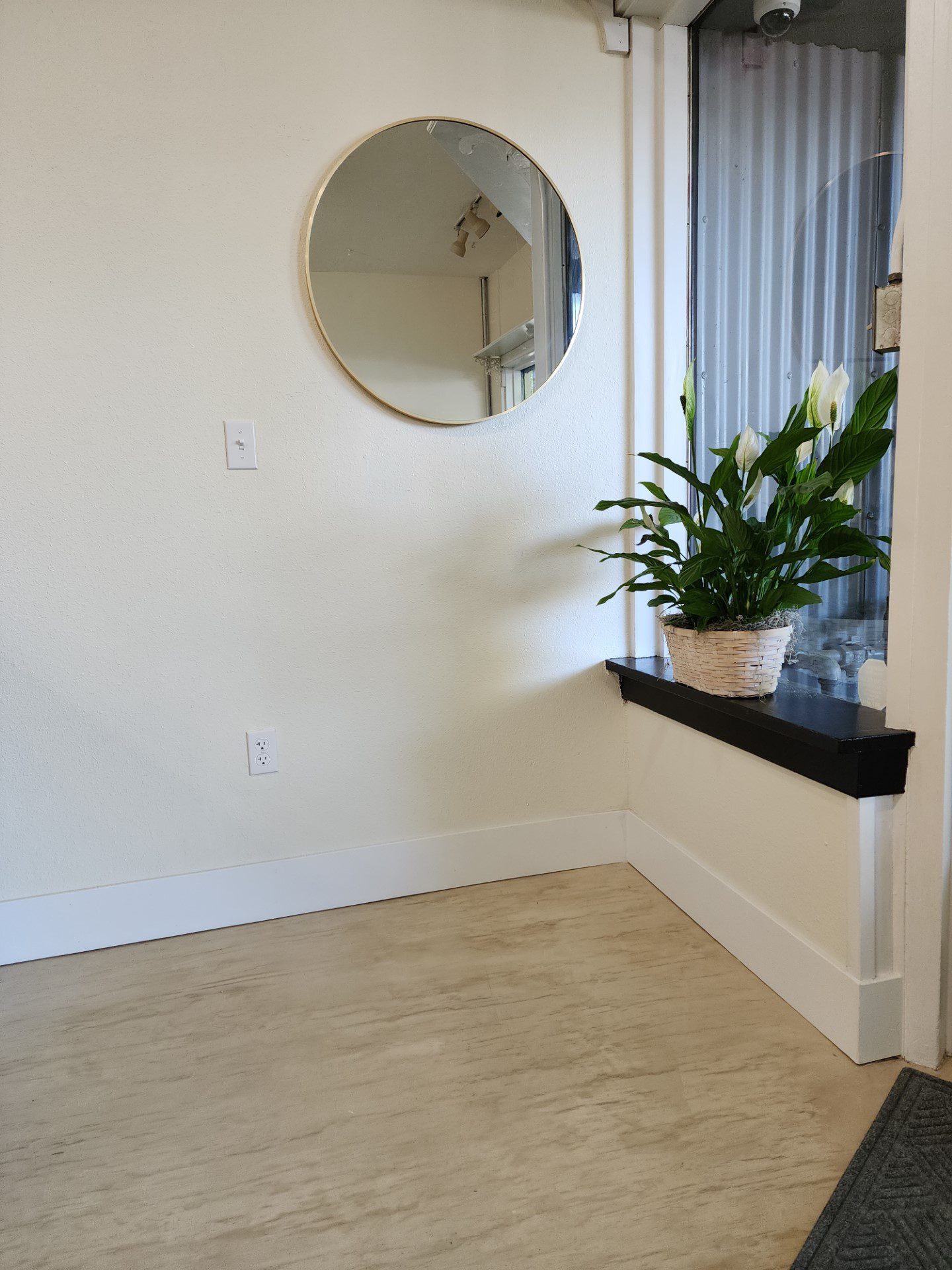 Photograph of the inviting entrance of a retail shop, highlighting the finished white concrete stained floor