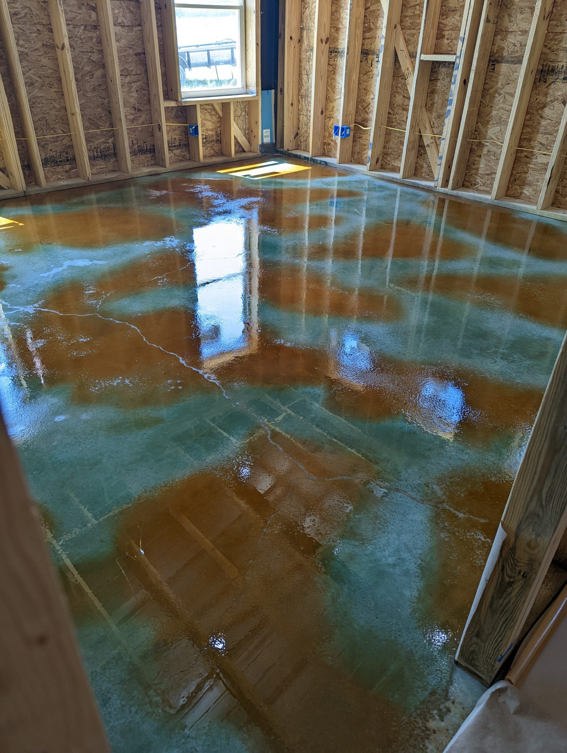 A photo of a concrete floor stained wet-on-wet with the Malayan Buff accent color over on Seagrass base color acid stain