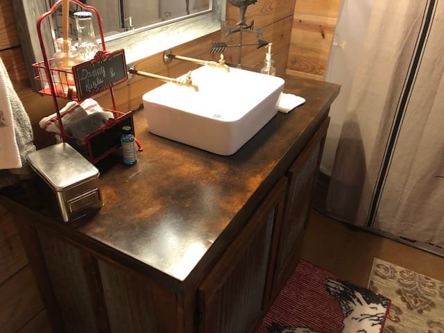 Elevating the rustic theme with this concrete vanity, perfectly stained with Coffee Brown. A beautiful blend with the Malayan Buff and Desert Amber flooring