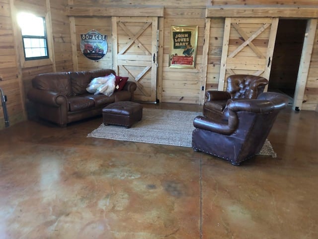 A spacious living room area with floors beautifully stained with Malayan Buff and Desert Amber, exuding a cozy farmhouse vibe