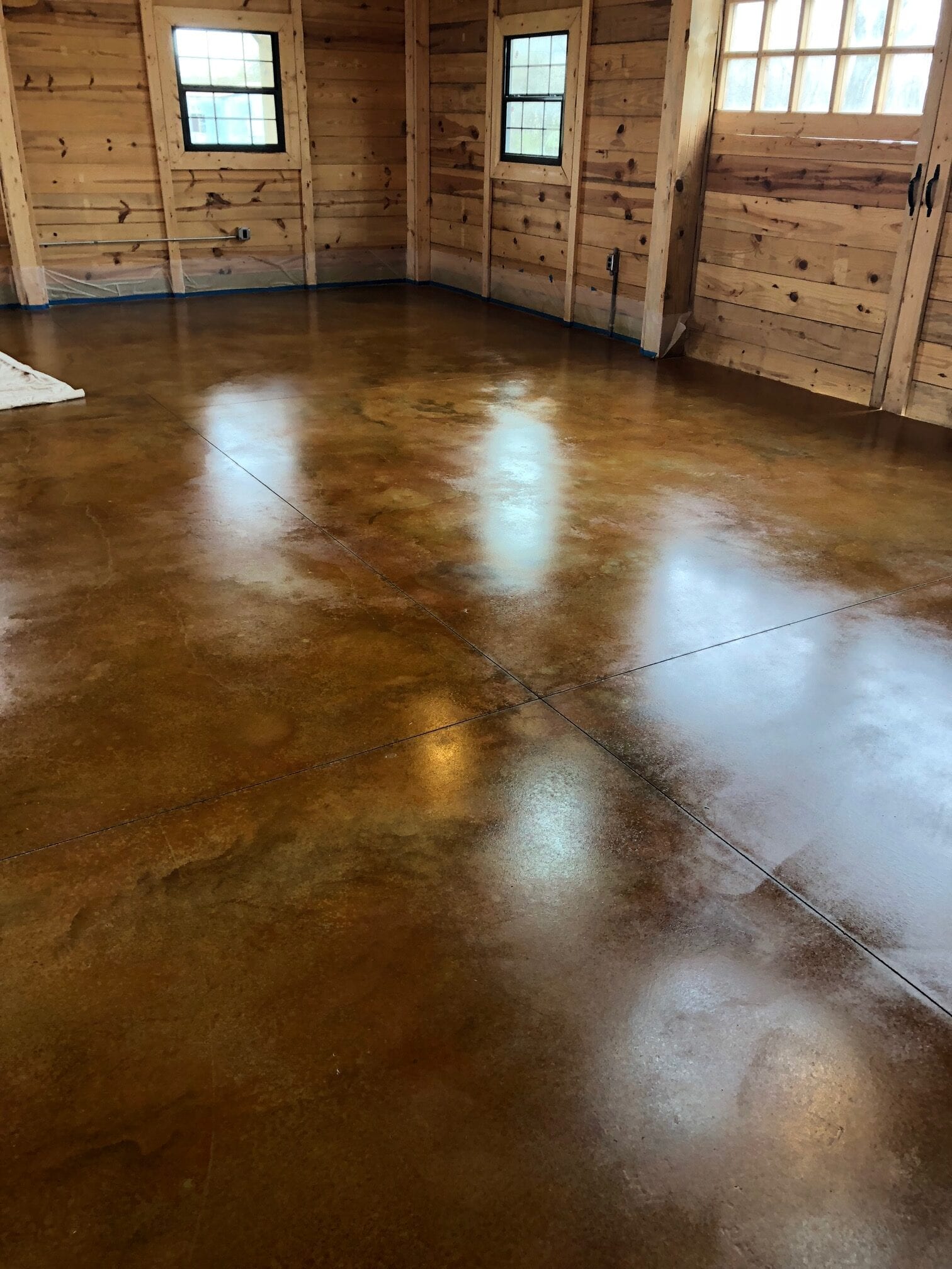 Closeup view of the textured floor stained with Malayan Buff and Desert Amber acid stain, showcasing the warm, earthy tones