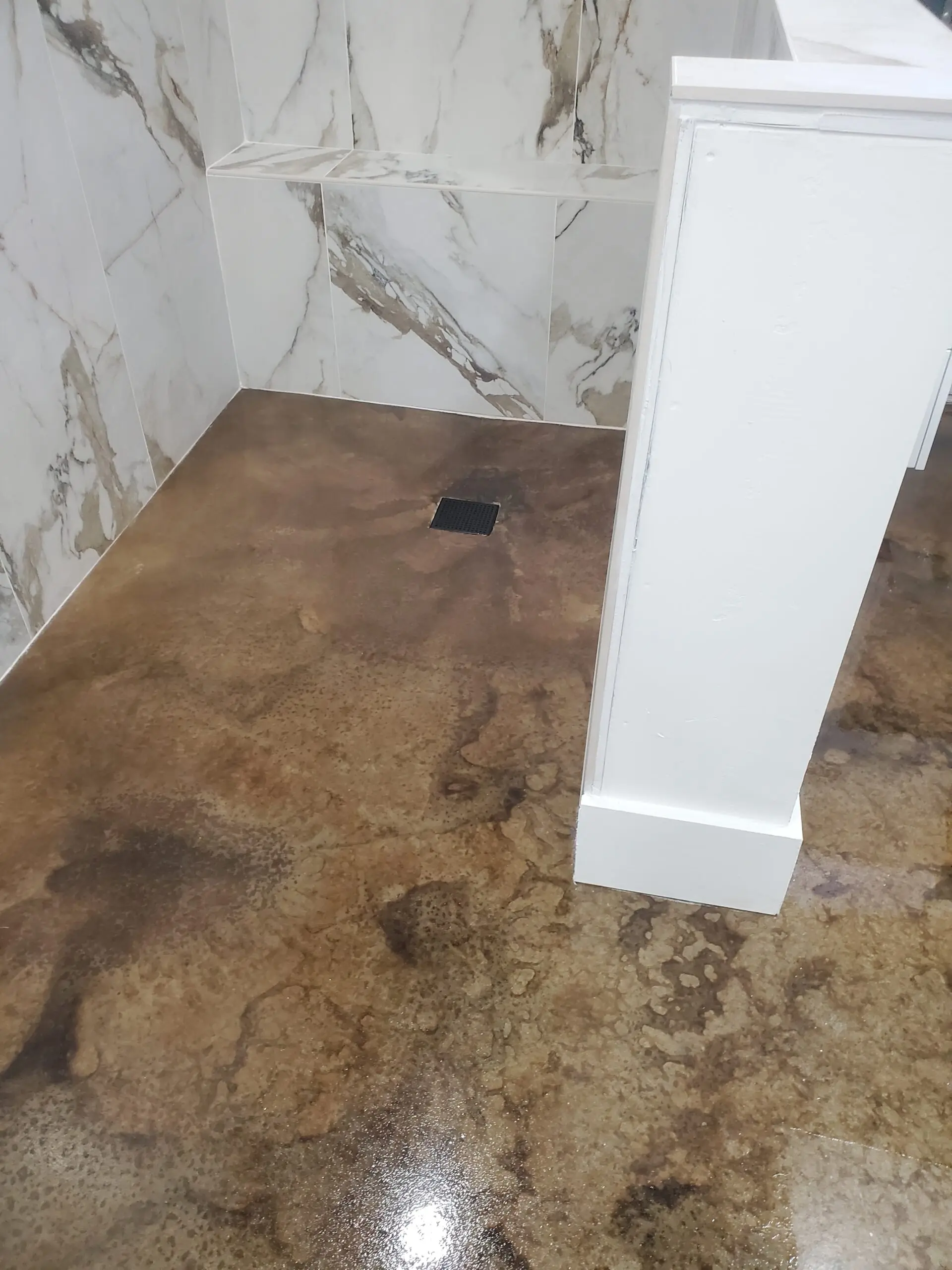 Bathroom floor with earthy acid stain in Black and English Red, matching marble-like tiles