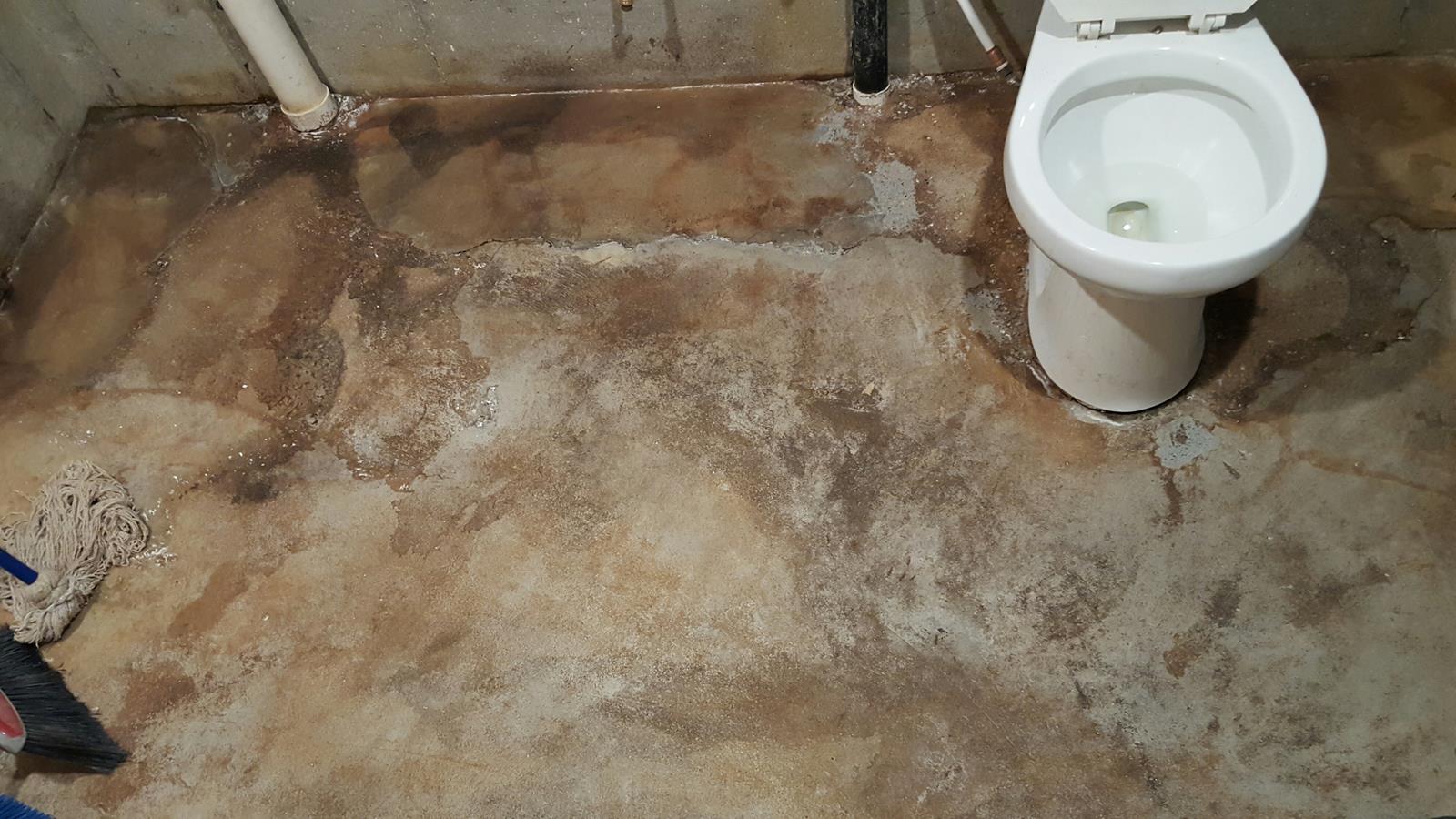 Badly damaged concrete bathroom floor