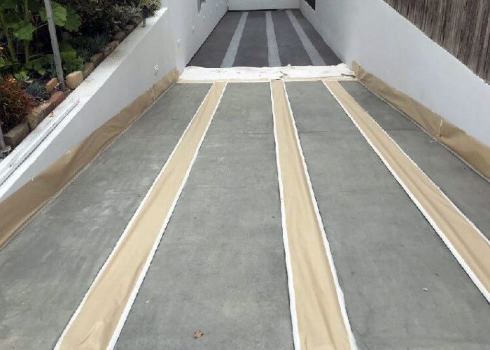 Image of a concrete driveway after the application of Stormy Gray Vibrance dye has dried, revealing a lighter shade that will be accentuated with the application of sealer.
