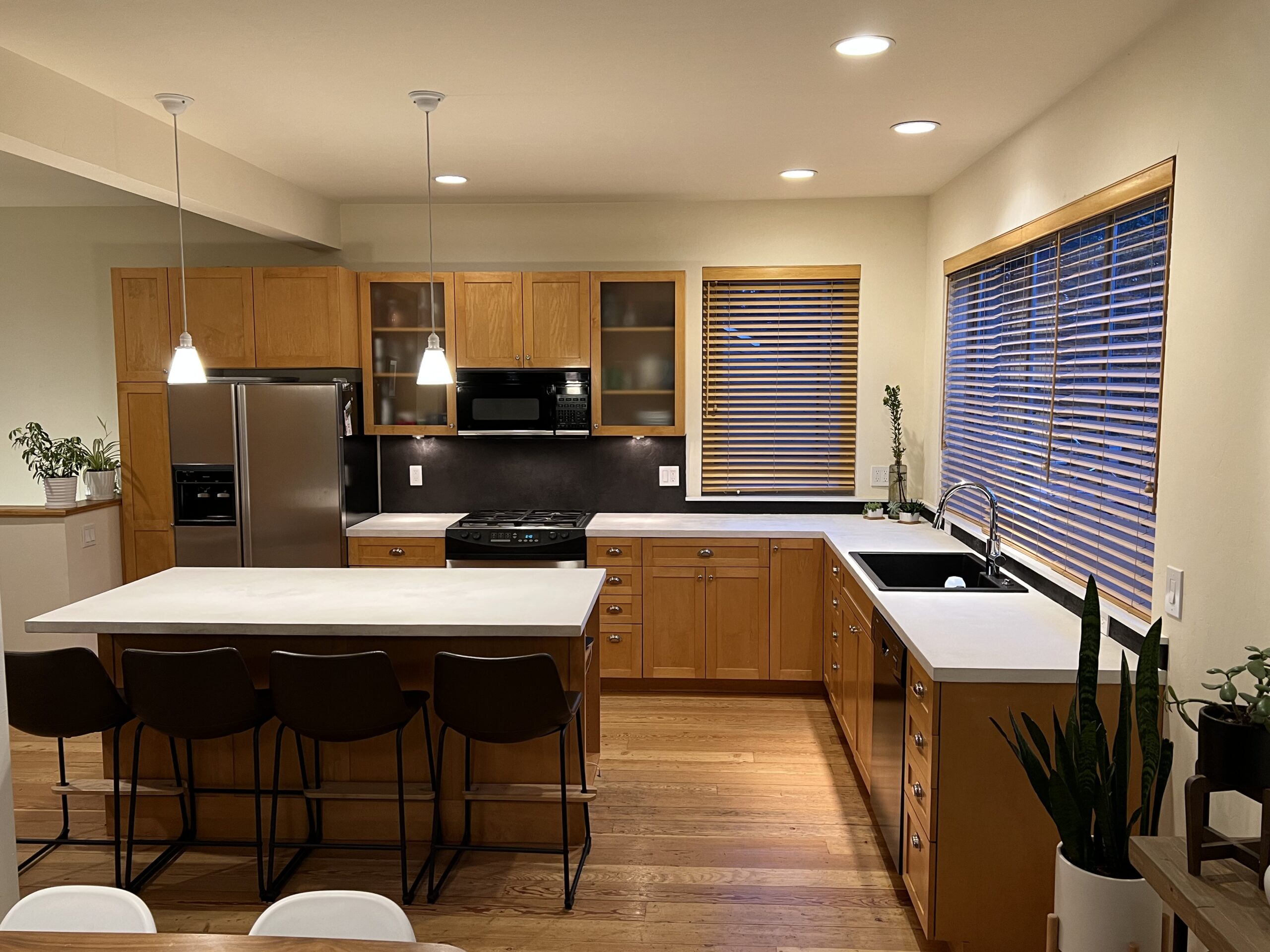 A kitchen renovation featuring a refinished Formica countertop with a pearl white concrete overlay and a tile backsplash with a titanium concrete overlay