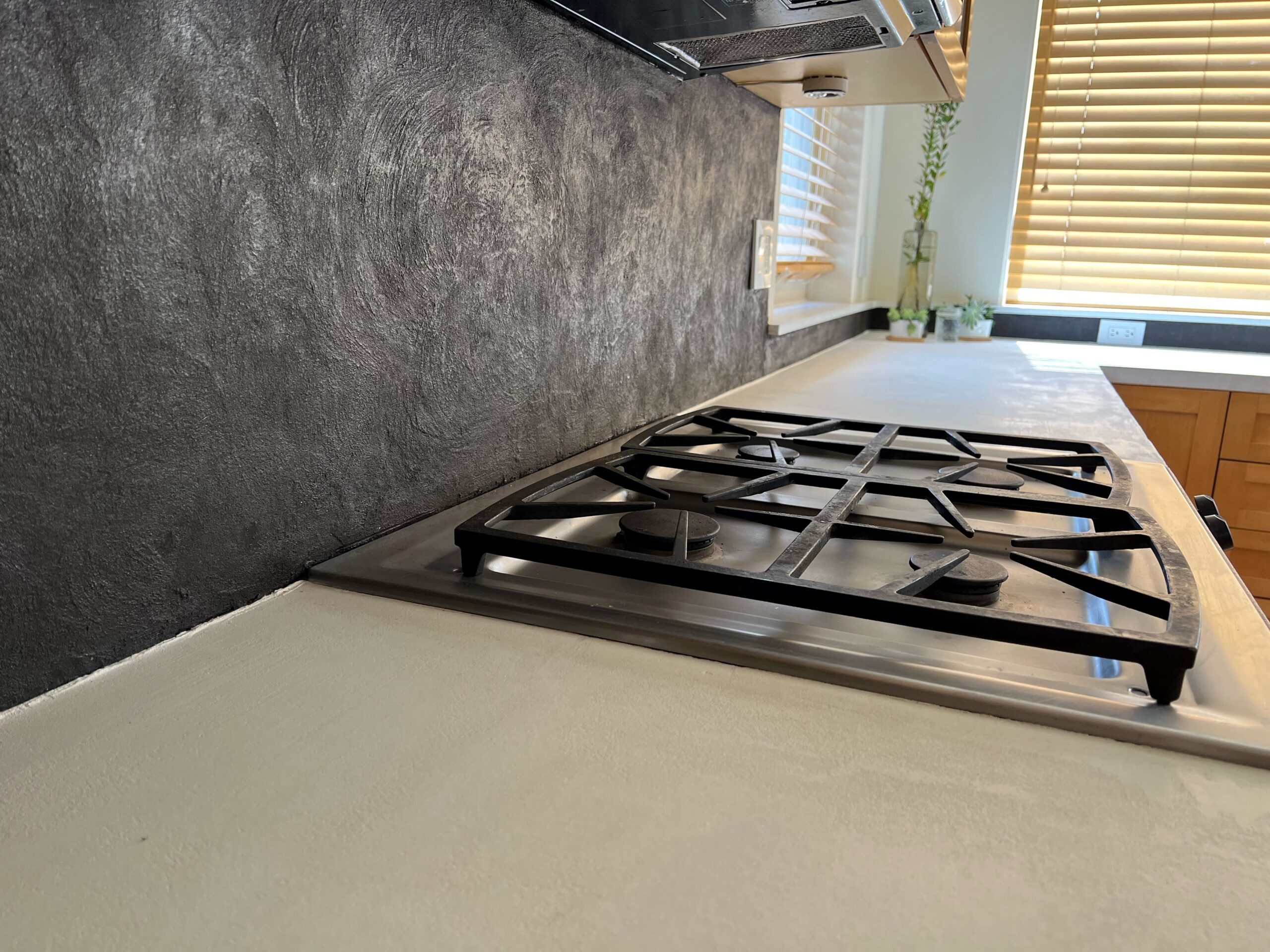 Refinished Formica countertop with a pearl white concrete overlay and a tile backsplash with a titanium concrete overlay.