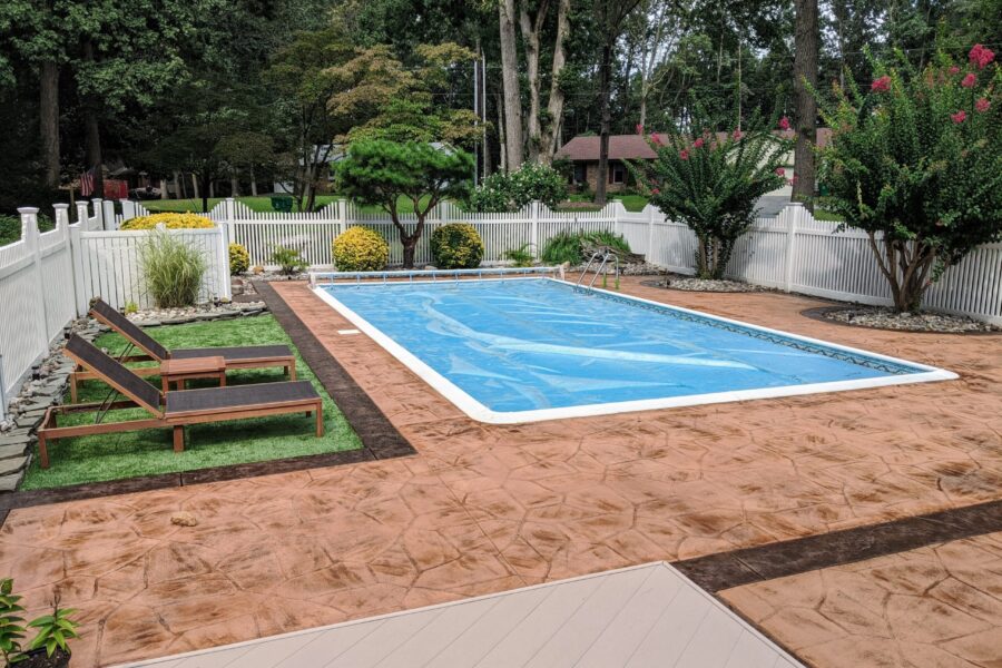 A Poolside Masterpiece: The elegant transformation of the once-drab stamped concrete pool deck, now adorned with a sophisticated stain and sealed for lasting beauty and safety