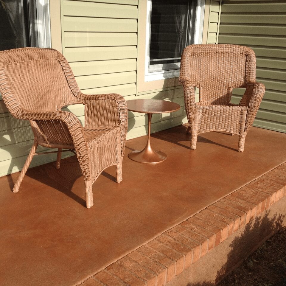 Terracotta stained concrete porch with a warm, earthy hue. The stain highlights the natural texture of the concrete for a unique and inviting look.