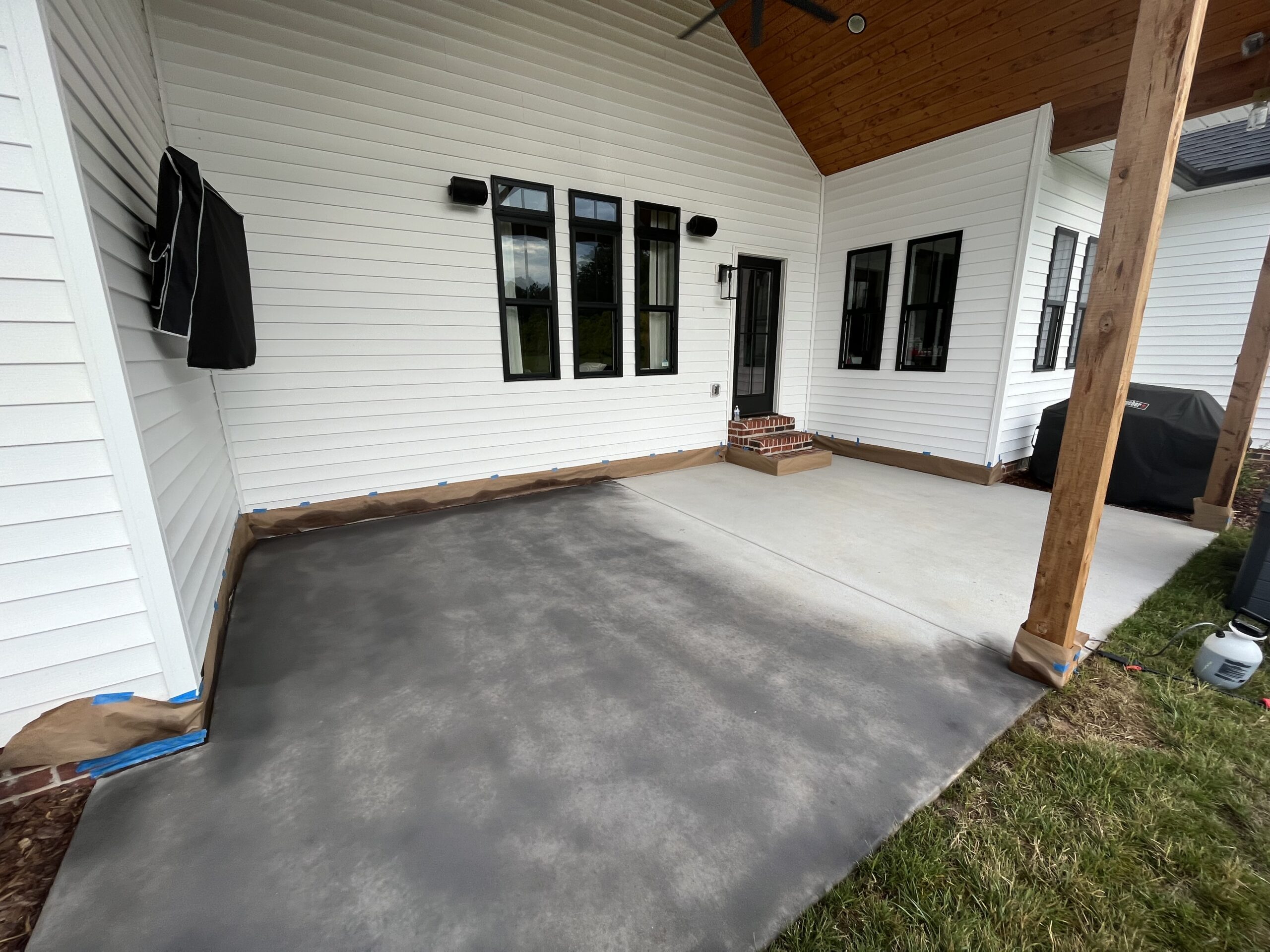 Process of applying gray concrete stain on a covered patio