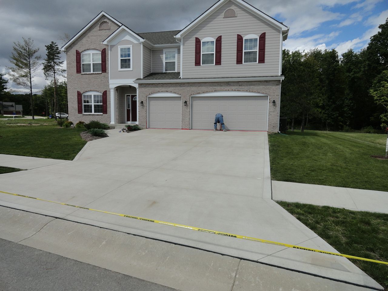 Before application: Large broomed concrete driveway of a two-story house before the Buff tint treatment