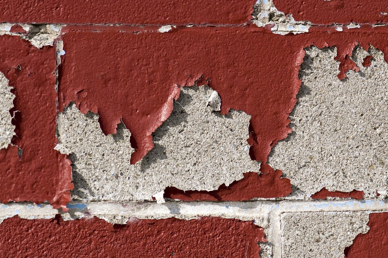 Red paint chips from an underlying concrete wall.