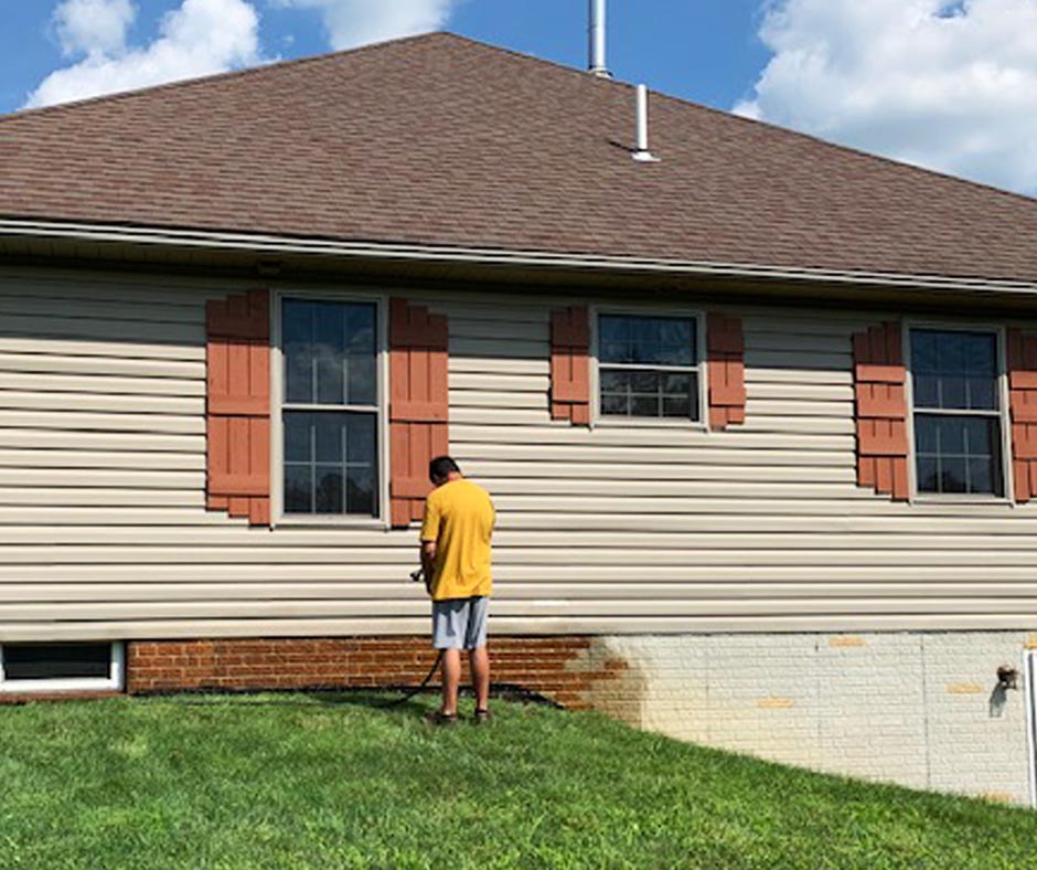 DIYer neutralizing the Cola DecoGel from the stamped faux brick wall using a water and baking soda solution.