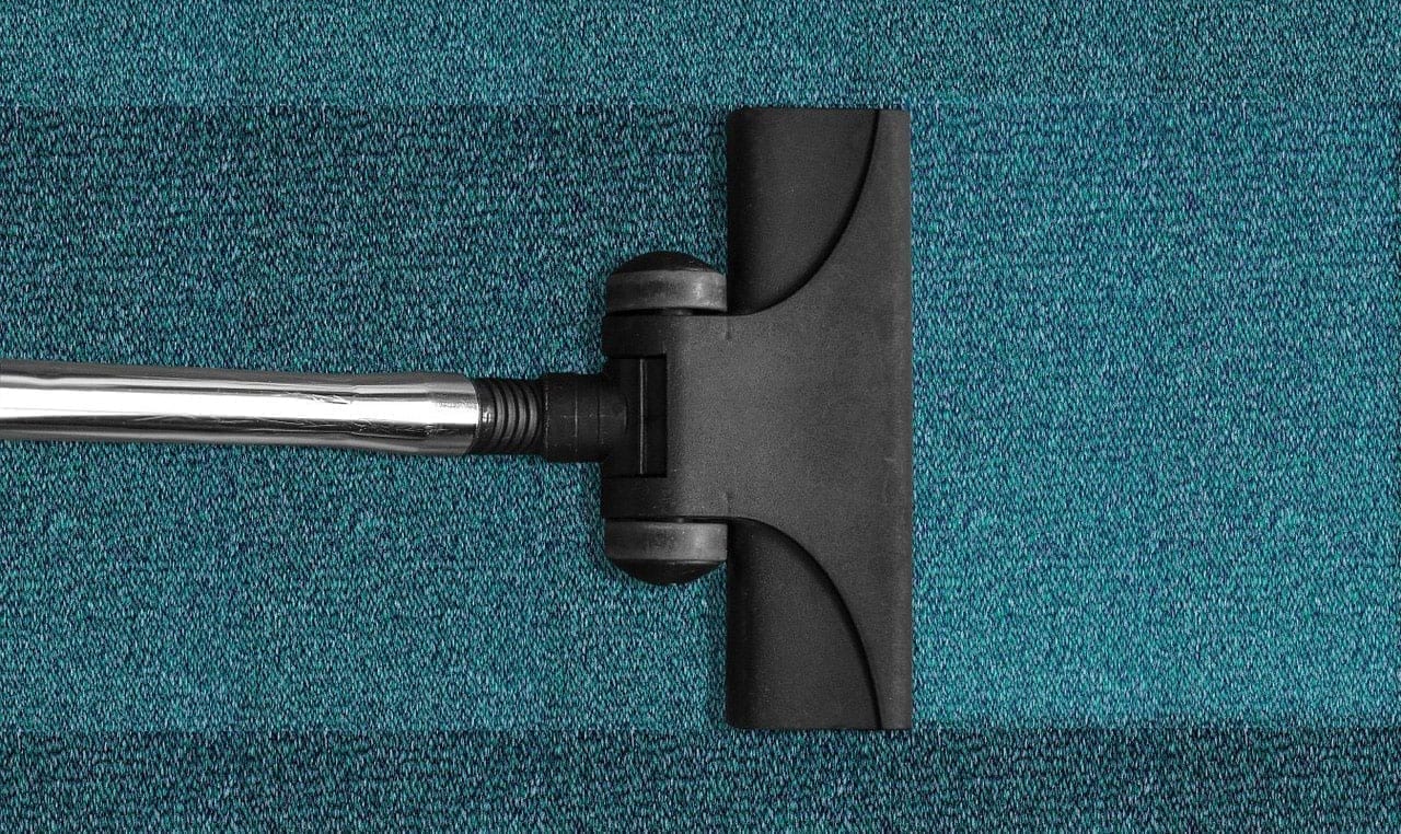 Vacuuming dirty carpets which is a big issue when it comes to comparing concrete vs. carpet flooring.