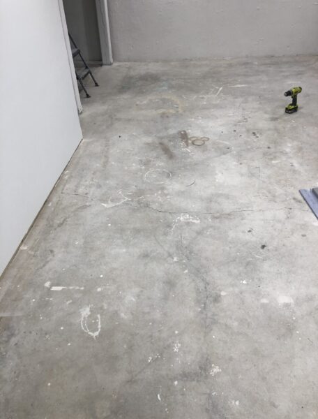 Basement floor with old stains, spray paint and overspray on it