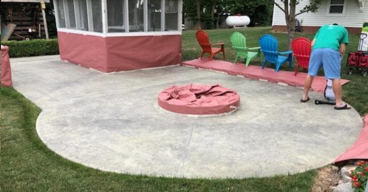 Circular stamped patio pre-staining, with protected edges and a covered brick fire pit at the center