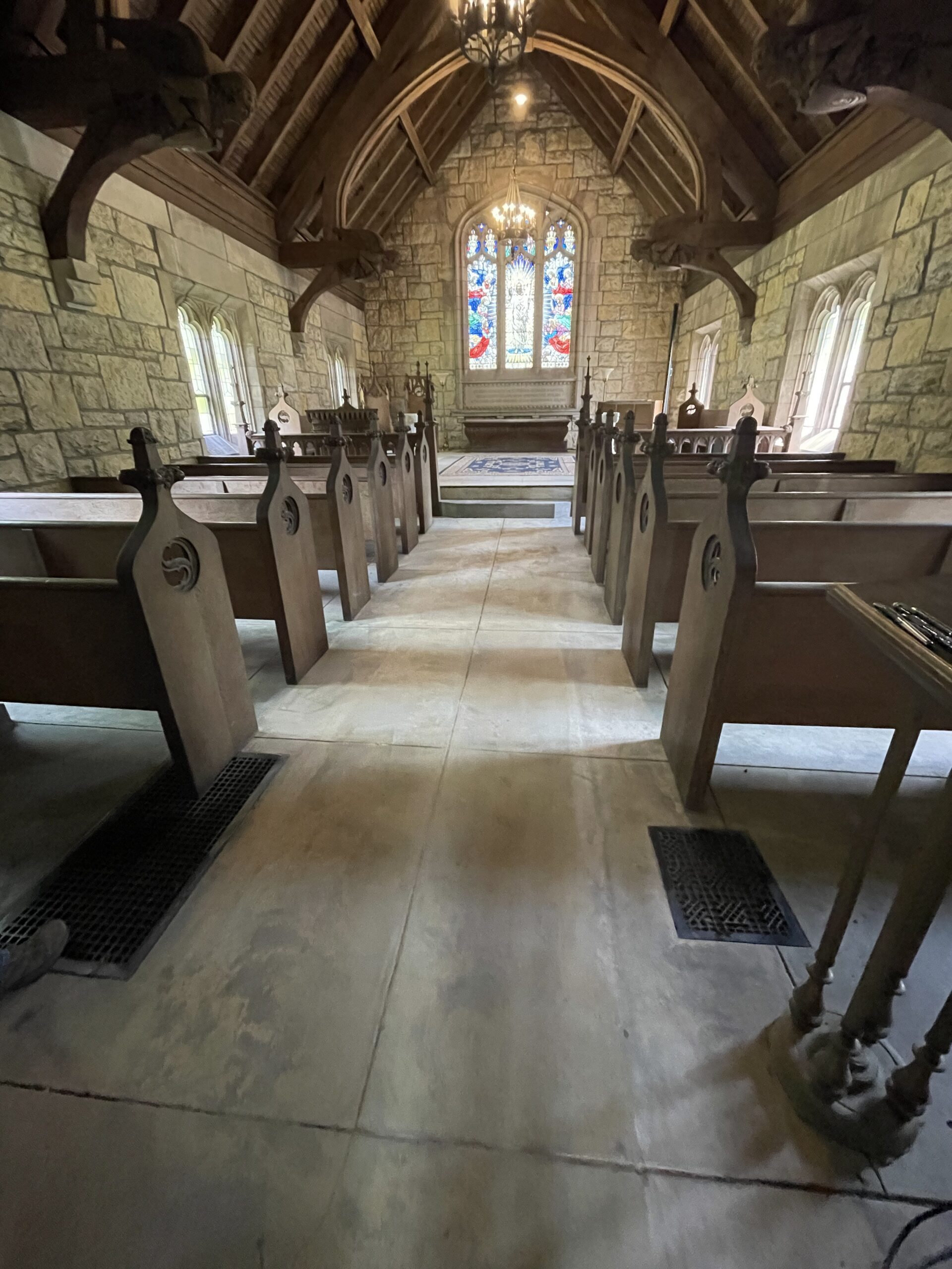 "Pre-renovation photo of the worn-out chapel floor, leading towards the altar