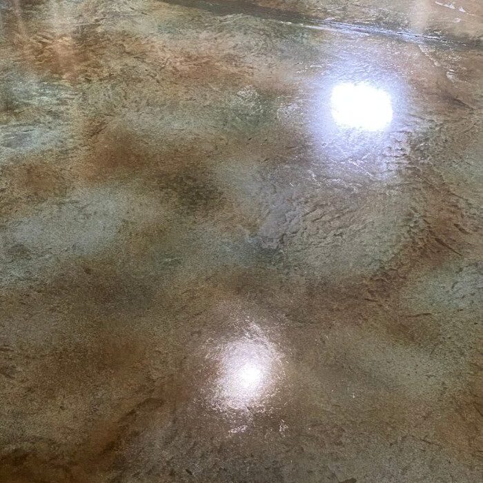 Polished concrete floor with an Azure Blue and Coffee Brown acid stain creating a subtle mottled effect that resembles a natural stone pattern.