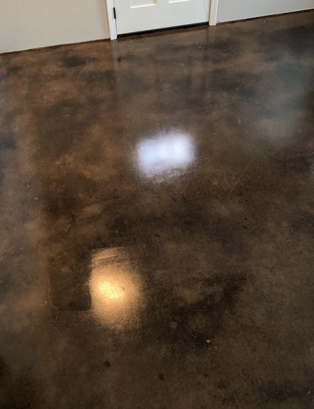 Concrete basement floor transformed into a warm space with coffee brown acid stain