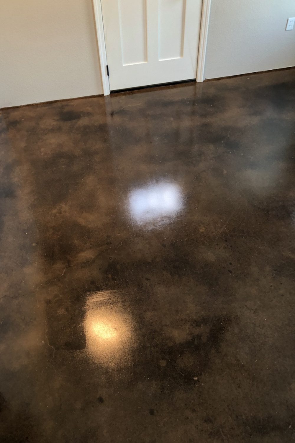 Concrete basement floor transformed into a warm space with coffee brown acid stain