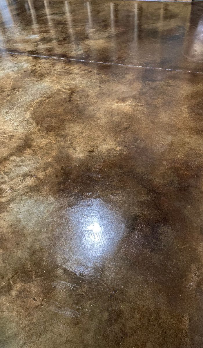 Stained concrete basement floor using coffee brown and desert amber acid stains to create a stunning leather look effect