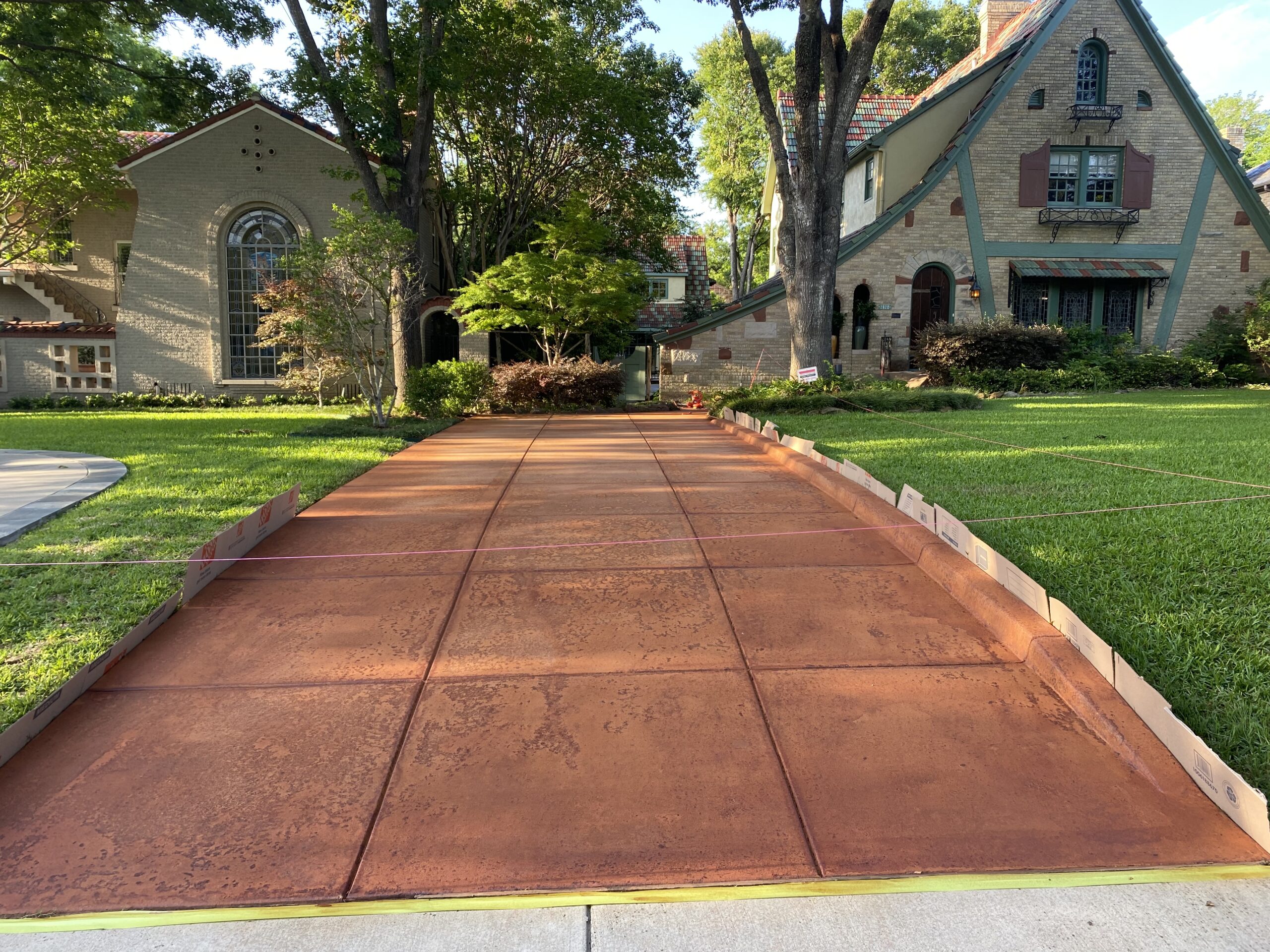 Revitalize your outdoor space with a pop of color! This scored concrete driveway was transformed with Tangerine ColorWave water-based stain, adding a touch of eco-friendly vibrancy