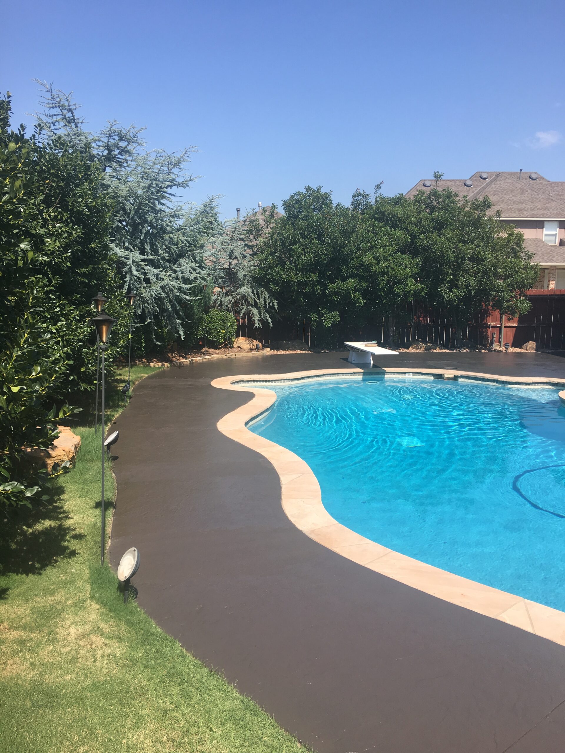 Rejuvenated pool deck after applying Resurface-It concrete overlay and Chocolate EasyTint