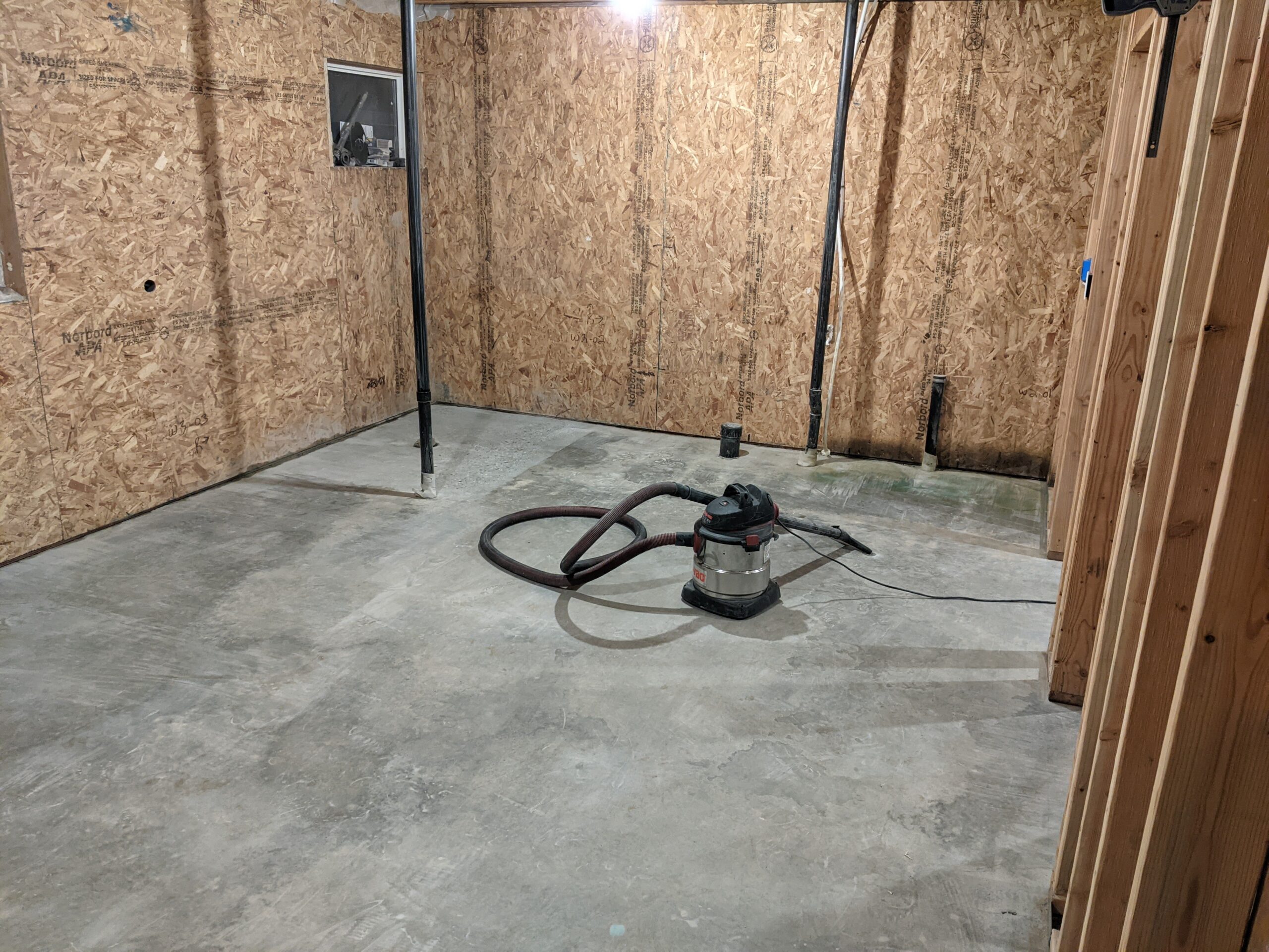 Image of an untreated, raw concrete floor in an unfinished walkout basement