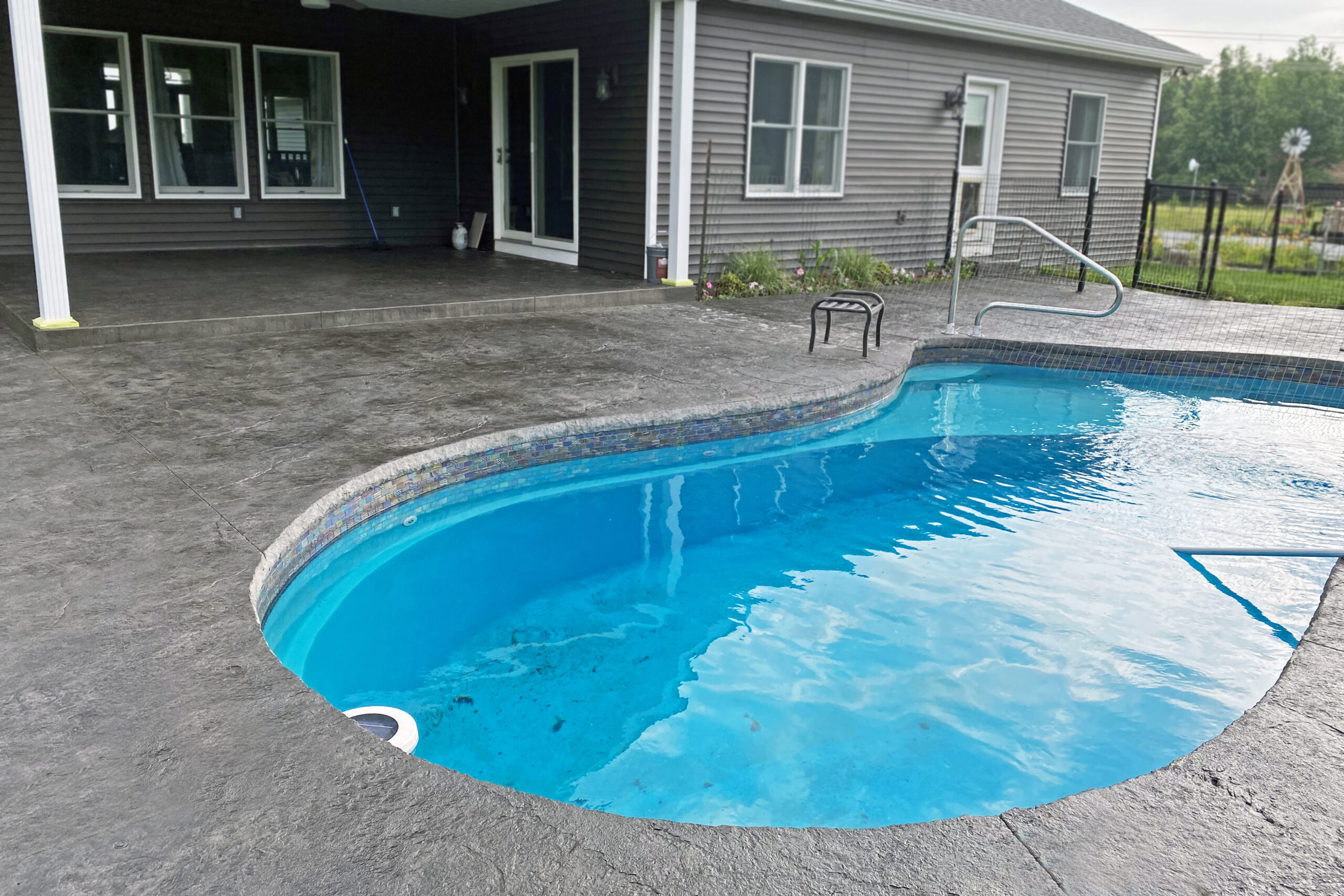 Rejuvenated stamped concrete pool area after application of Black Antiquing stain and EasySeal high gloss sealer.