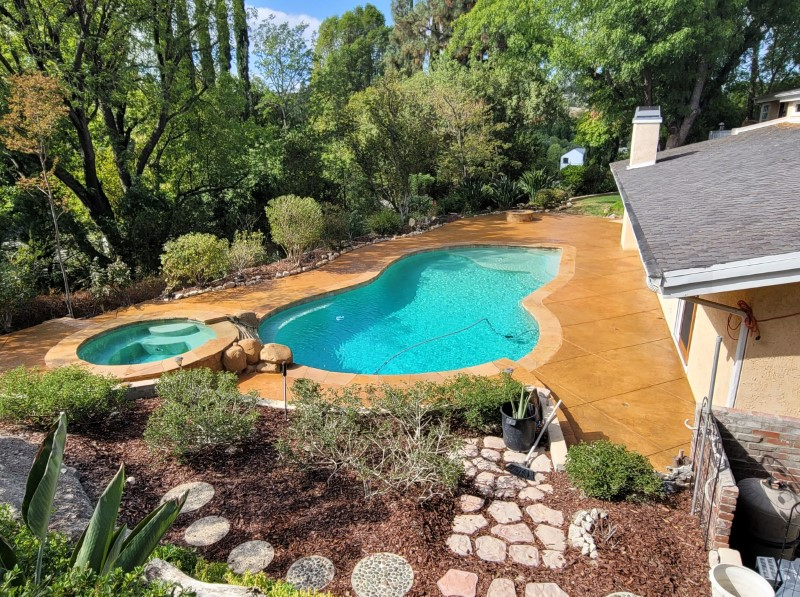 The same concrete space transformed into a vibrant backyard haven after staining with Yukon Gold Antiquing Stain and sealing with Solvent Based Acrylic Satin Concrete Sealer
