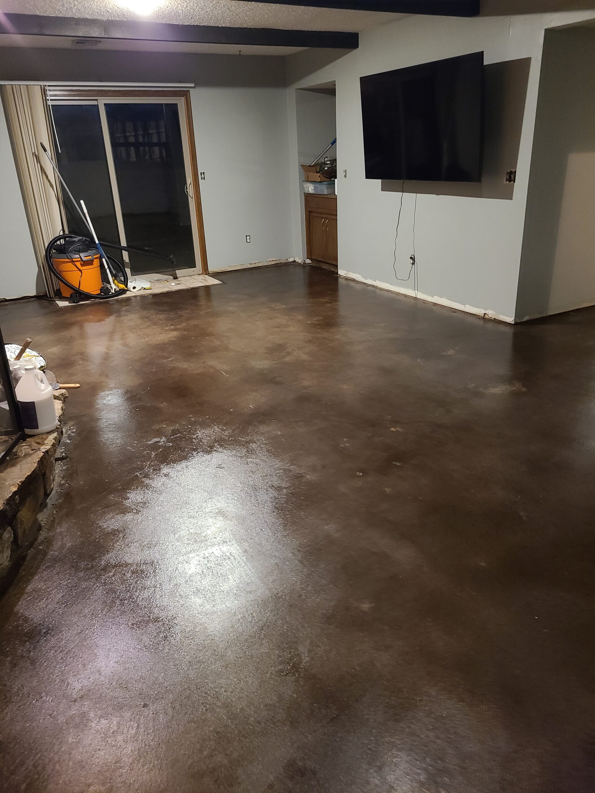 Polished black acid stained concrete basement floor