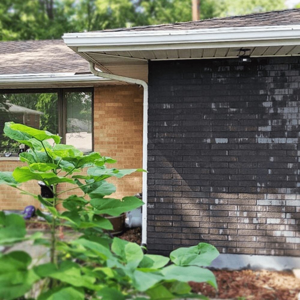 Revitalizing an old red brick exterior with a fresh coat of gray limewash for a timeless look.