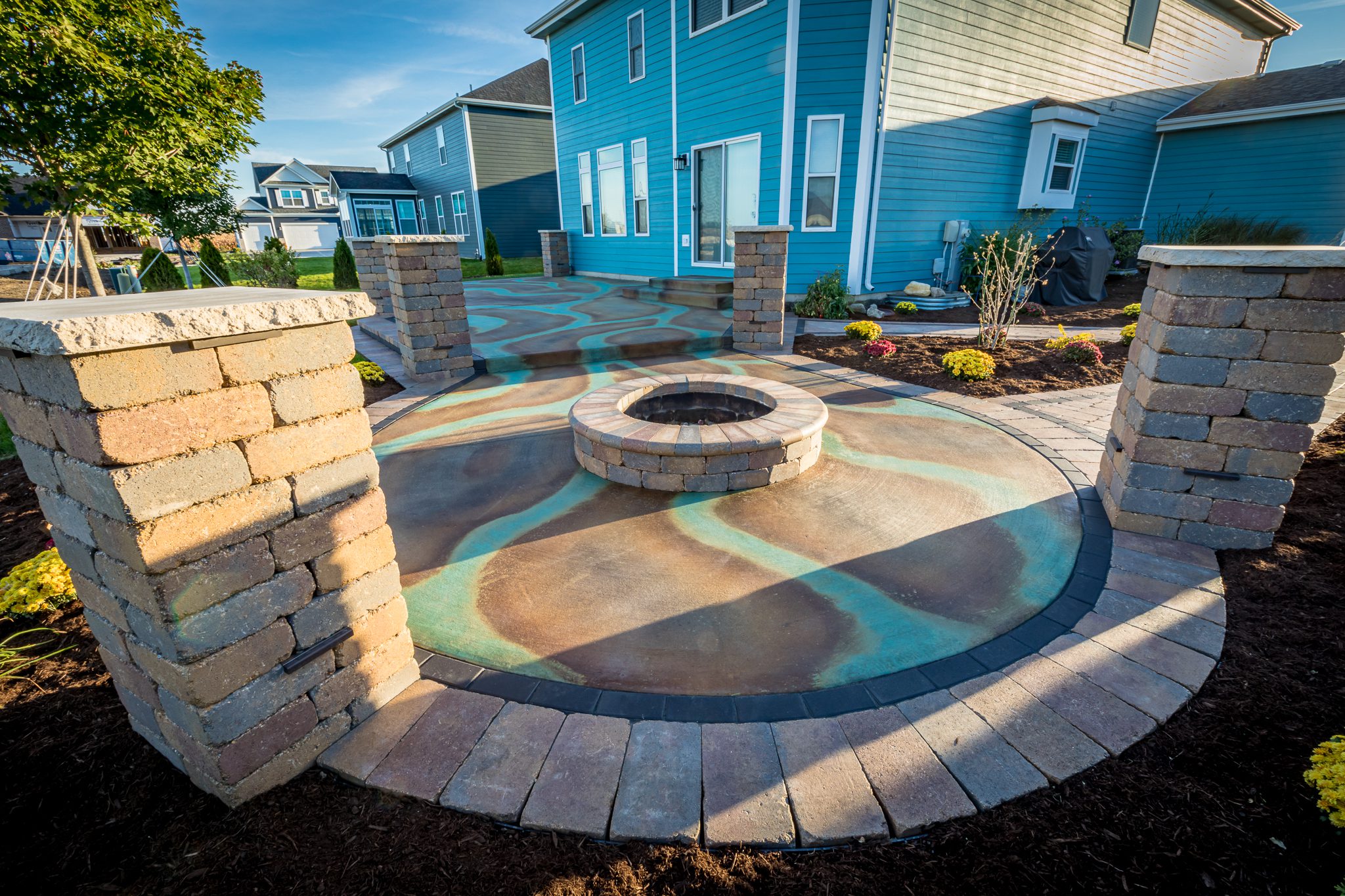 The finished stained and sealed patio showcases the beautiful multi-colored effect created by using Black and Malayan Buff acid stains to add depth and contrast to the Seagrass streaks.