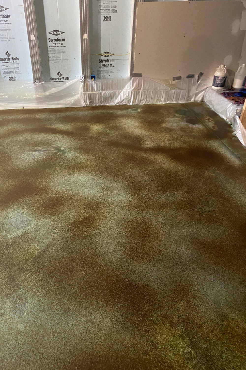 A photo of a dry concrete basement floor with the acid stain fully dried and ready to be neutralized before the final cleaning and rinsing process