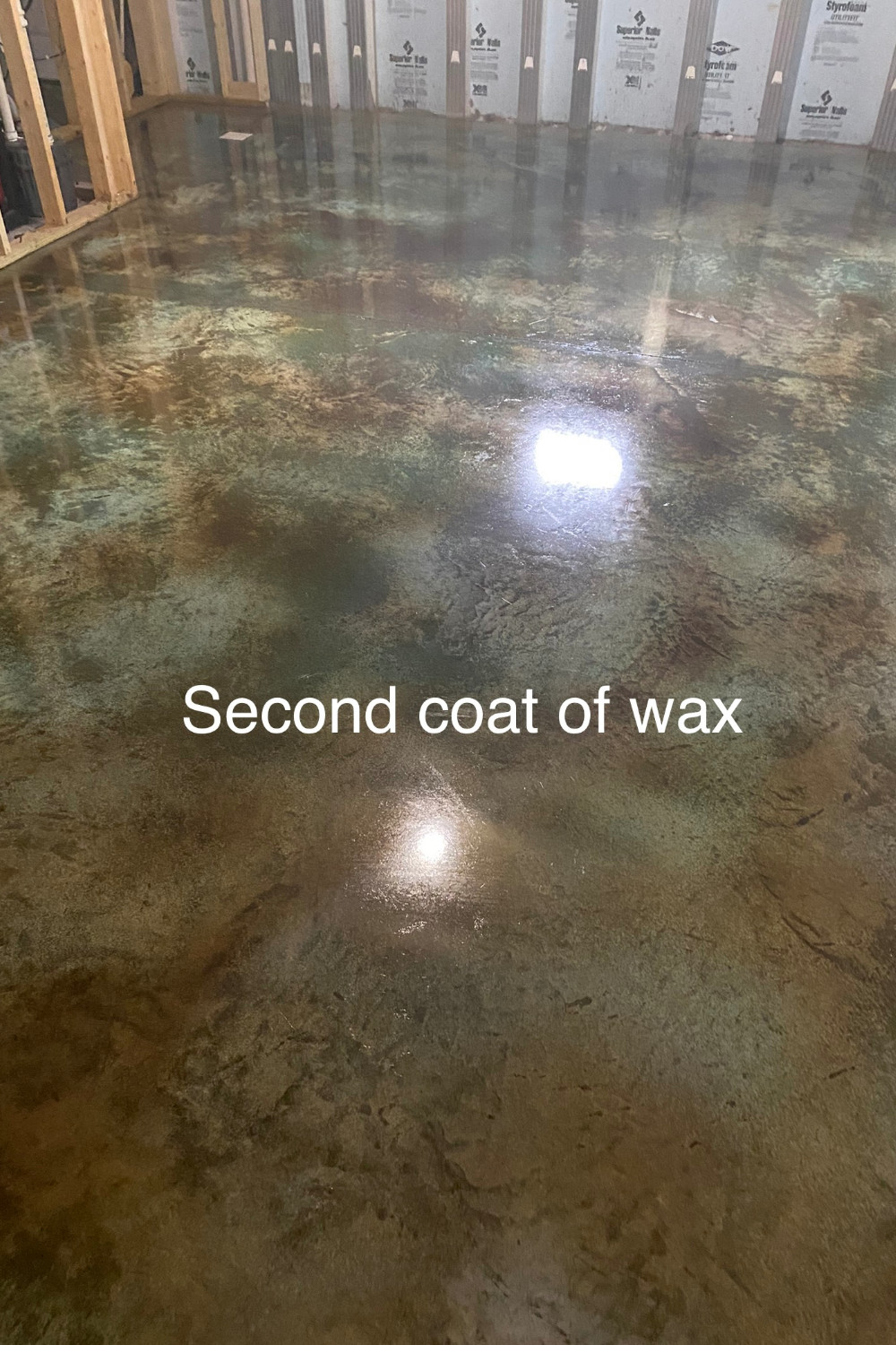 A photo of a concrete floor with the second coat of concrete floor wax applied, showing a glossy and protected surface