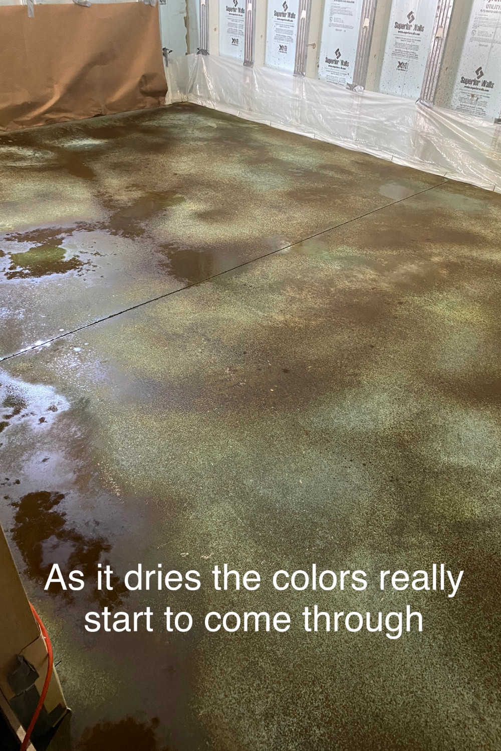 A photo of a concrete basement floor with the Coffee Brown accent color drying over the dried Azure Blue base color acid stain