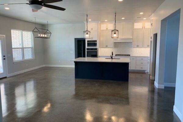 Concrete kitchen floor showcasing a modern mix of Stormy Gray, Driftwood, and Charcoal Vibrance Dye.