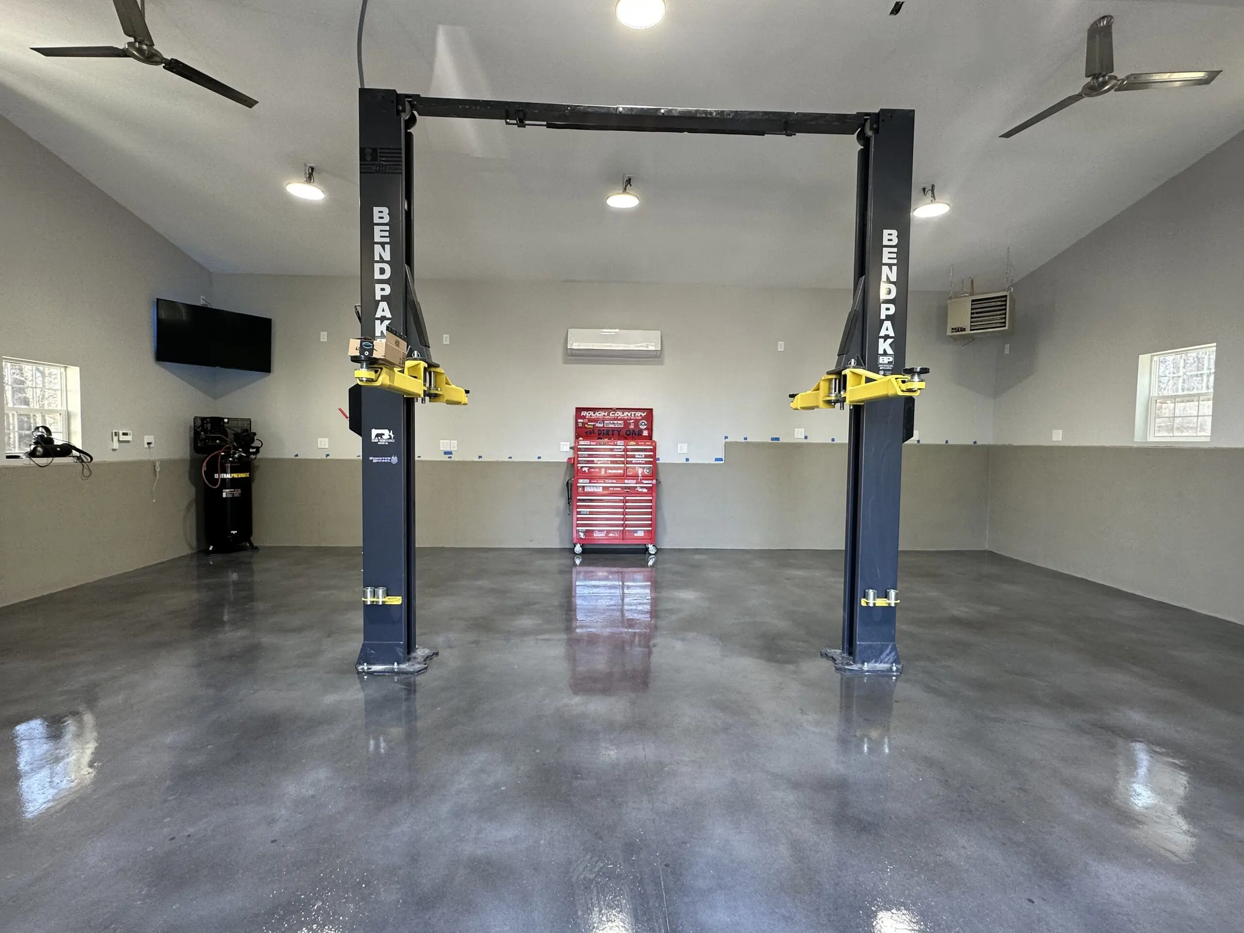 Finished garage floor with a sleek, polished look achieved using Charcoal, Stormy Gray, and White Vibrance Dye, topped with a polyaspartic clear coat for durability and garage-ready use.