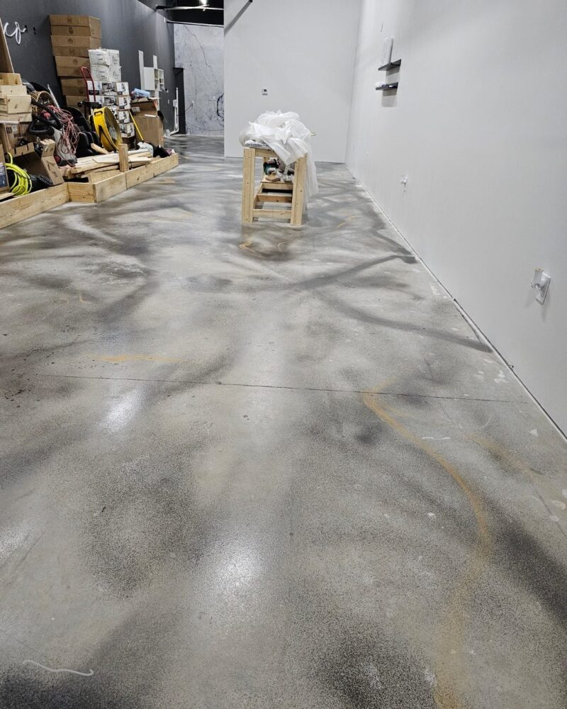 Artistically applied swirls of Charcoal AcquaTint and Mica highlights on the concrete salon floor.