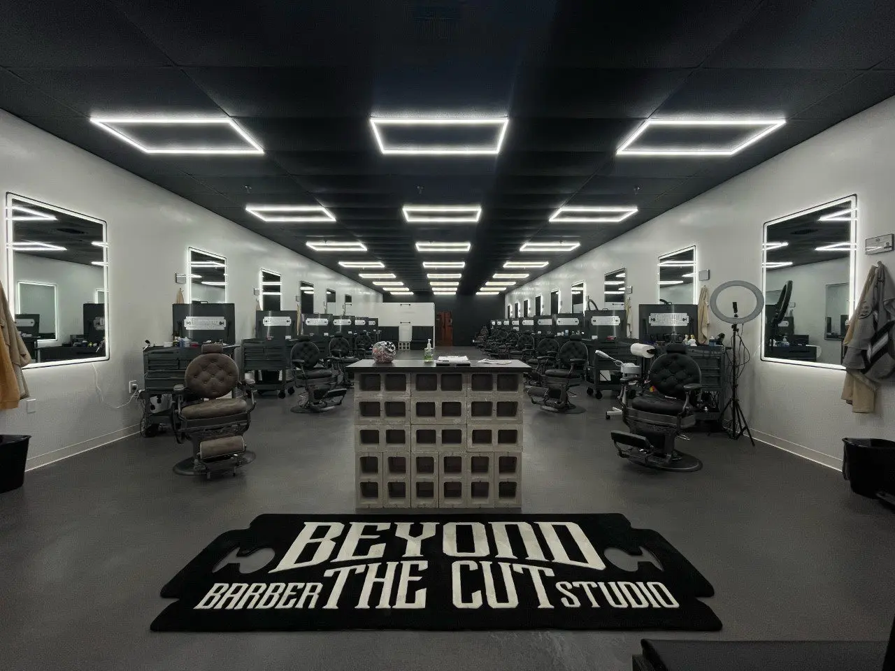 Image showcasing the finished concrete floor in the newly opened barbershop, featuring modern, industrial aesthetics with varying tones of gray and black, exuding a masculine ambiance.