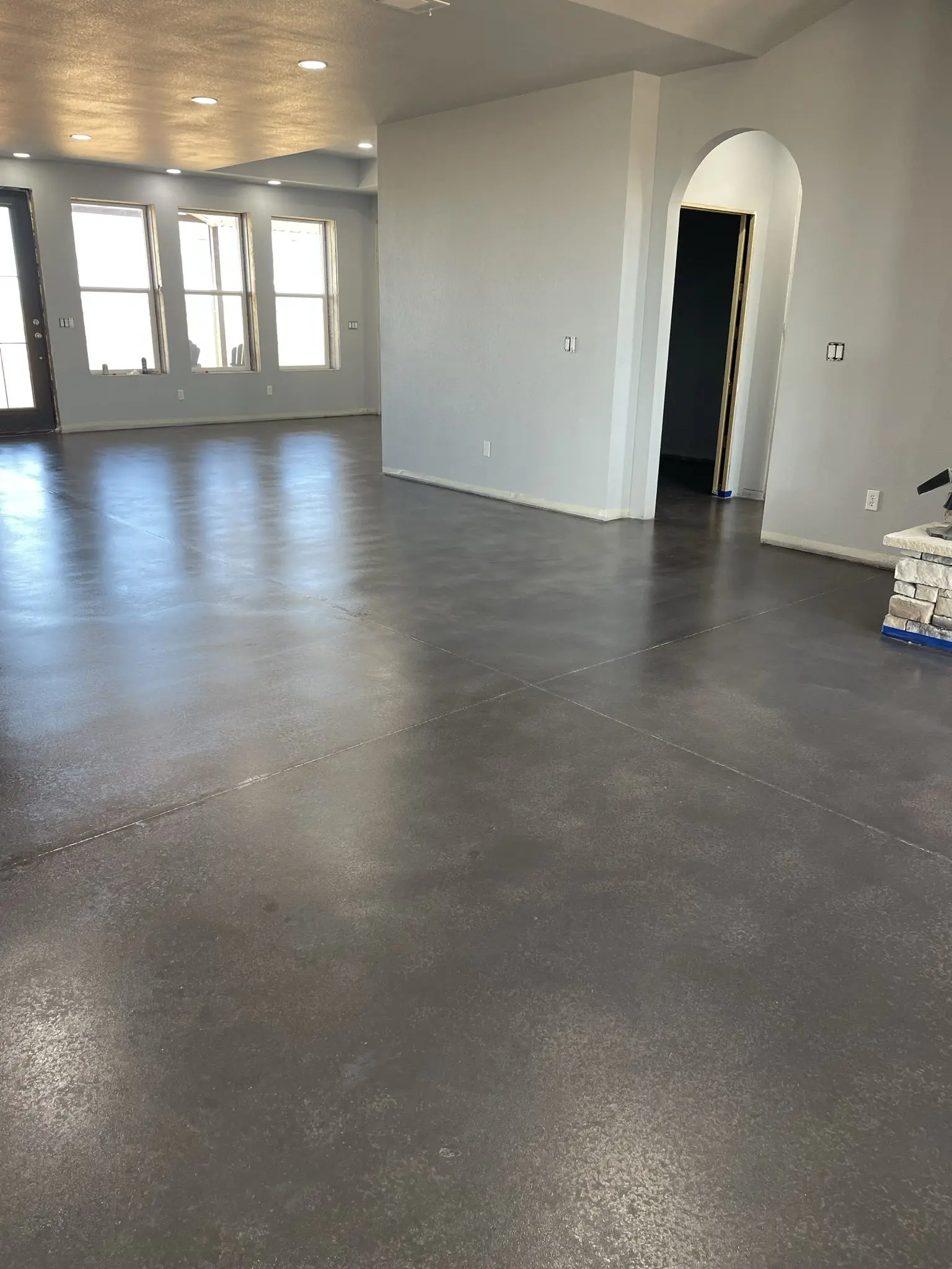 Gleaming concrete floor showcasing the result of two coats of light charcoal Aquatint and two layers of ProWax Polish gloss finish.