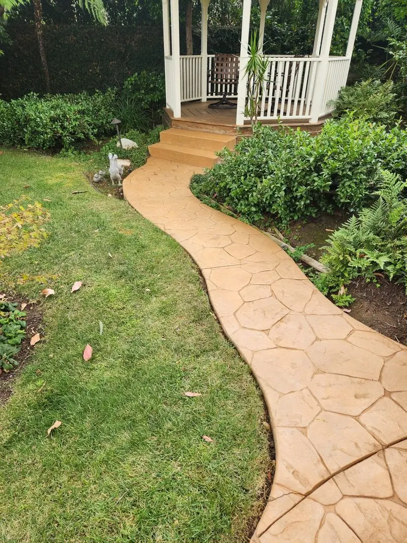 Winding walkway stained in warm Yukon Gold leading up to a welcoming gazebo amidst lush greenery.