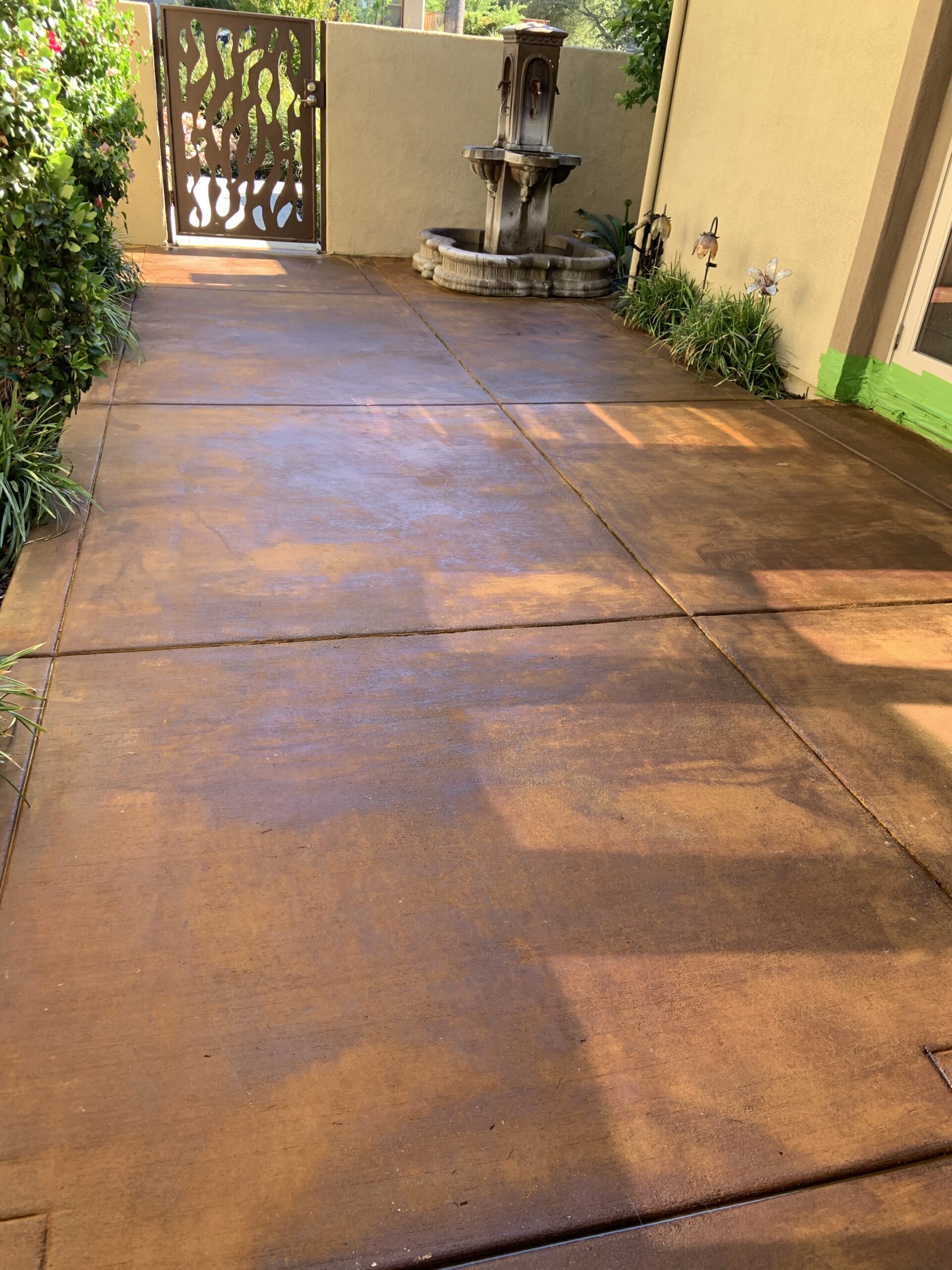 Revitalized 200 sq. ft. courtyard, displaying the warm, orange-brown hues of the applied Cola acid stain