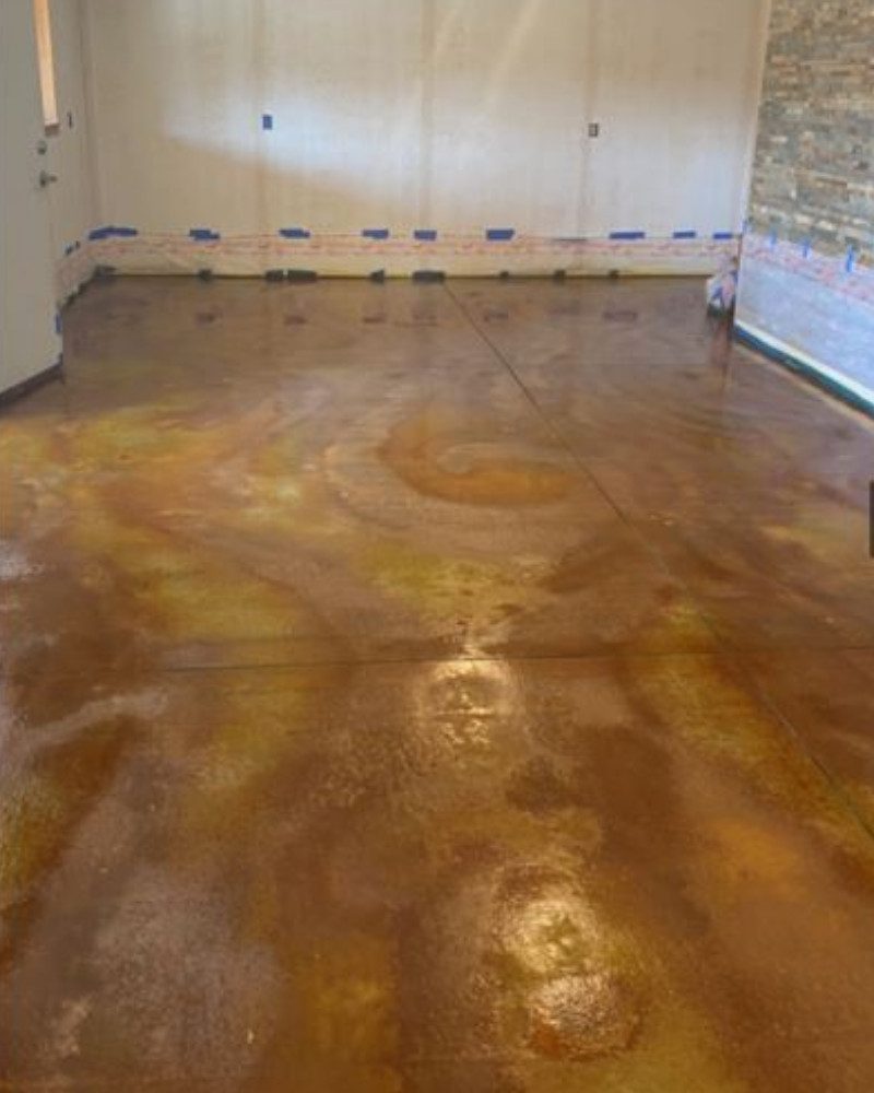 Old concrete floor after the application of Malayan Buff acid stain over the Desert Amber acid stain swirls