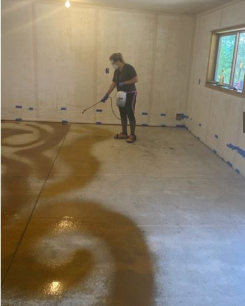 Applying desert amber acid stain on an old concrete floor in a fun swirling design