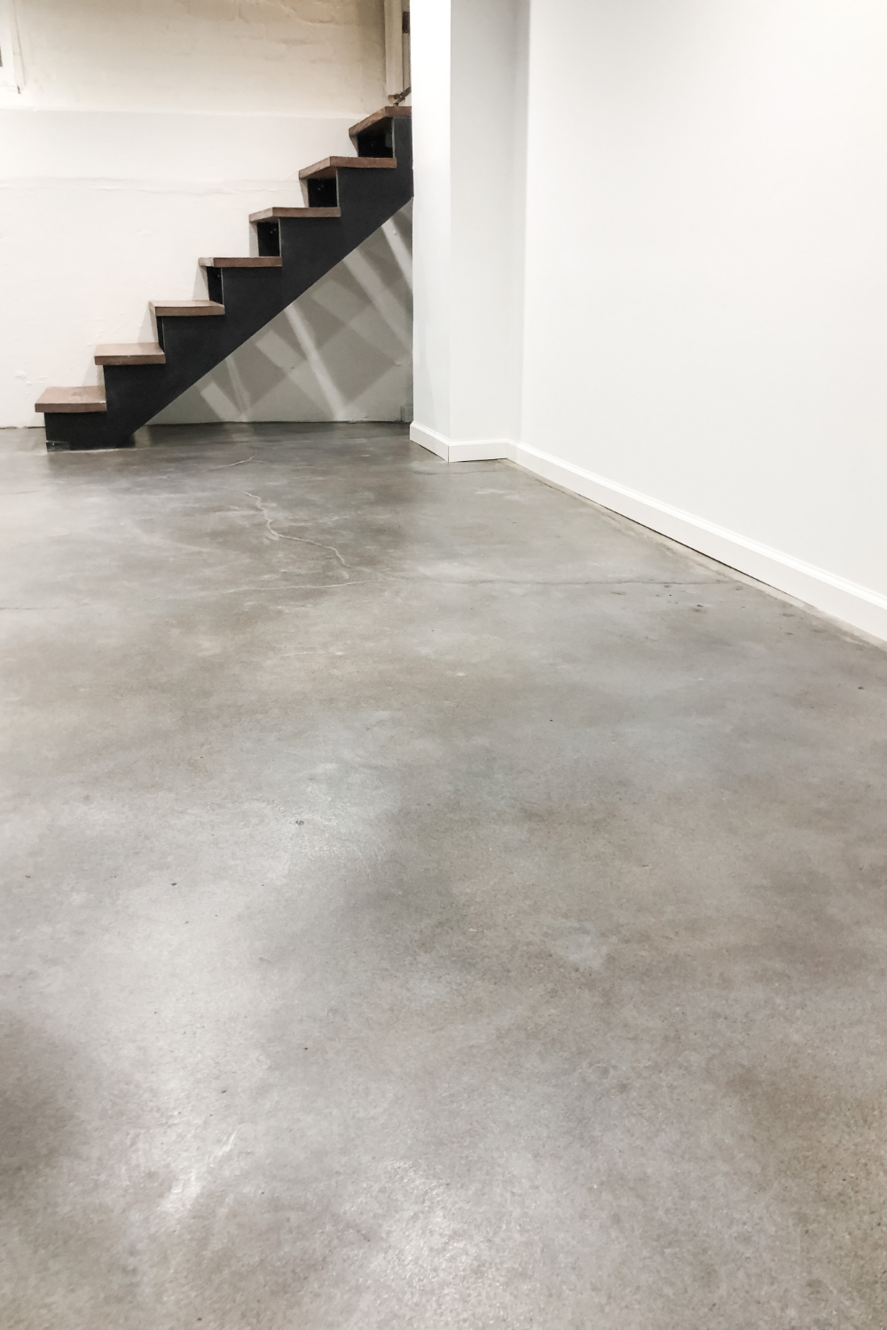 A close-up of the finished basement floor stained with Vibrance Dye in Stormy Gray, White, and Charcoal.