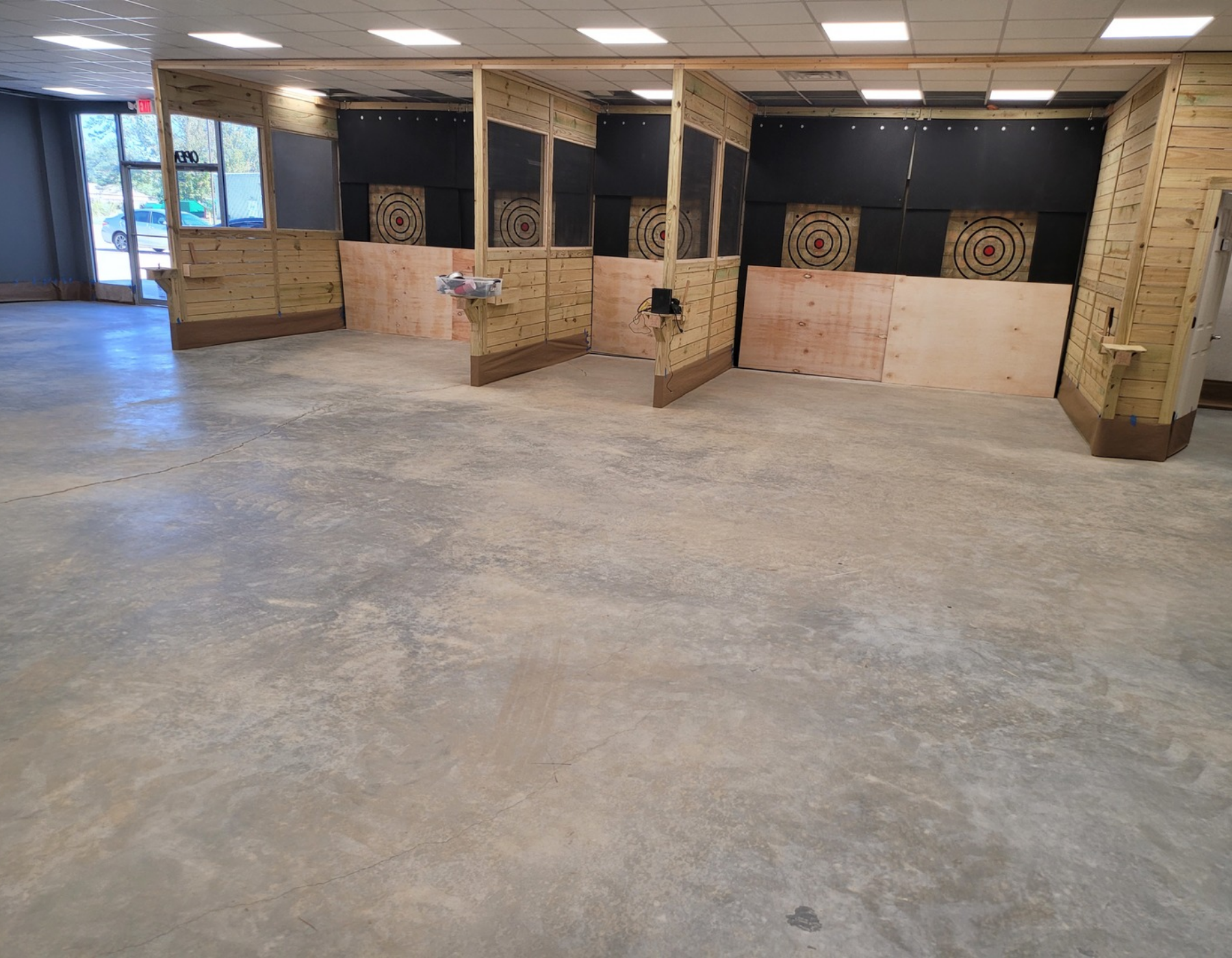 Unfinished concrete floor of an axe-throwing bar before staining