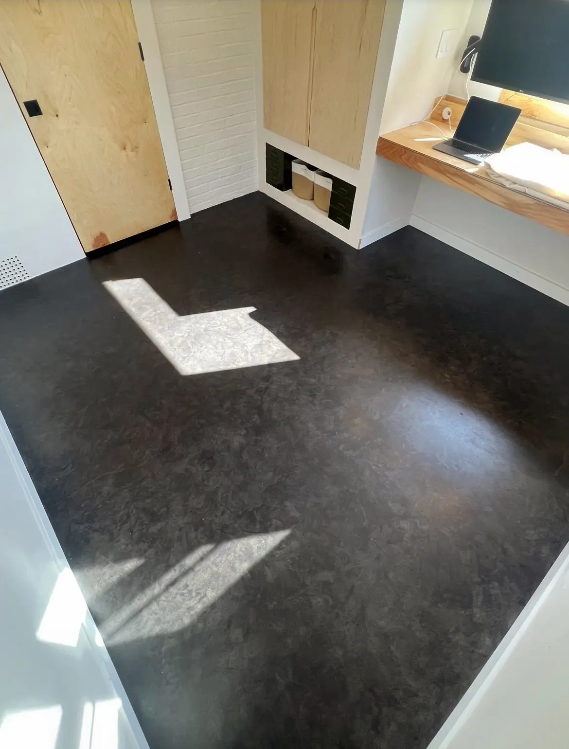 Final look of a concrete floor gleaming with a matte finish after the application of Behr Concrete Sealer.