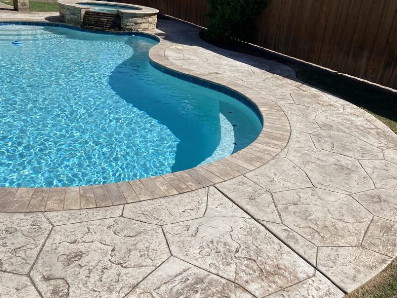 The original faded stamped concrete pool deck prior to the staining process