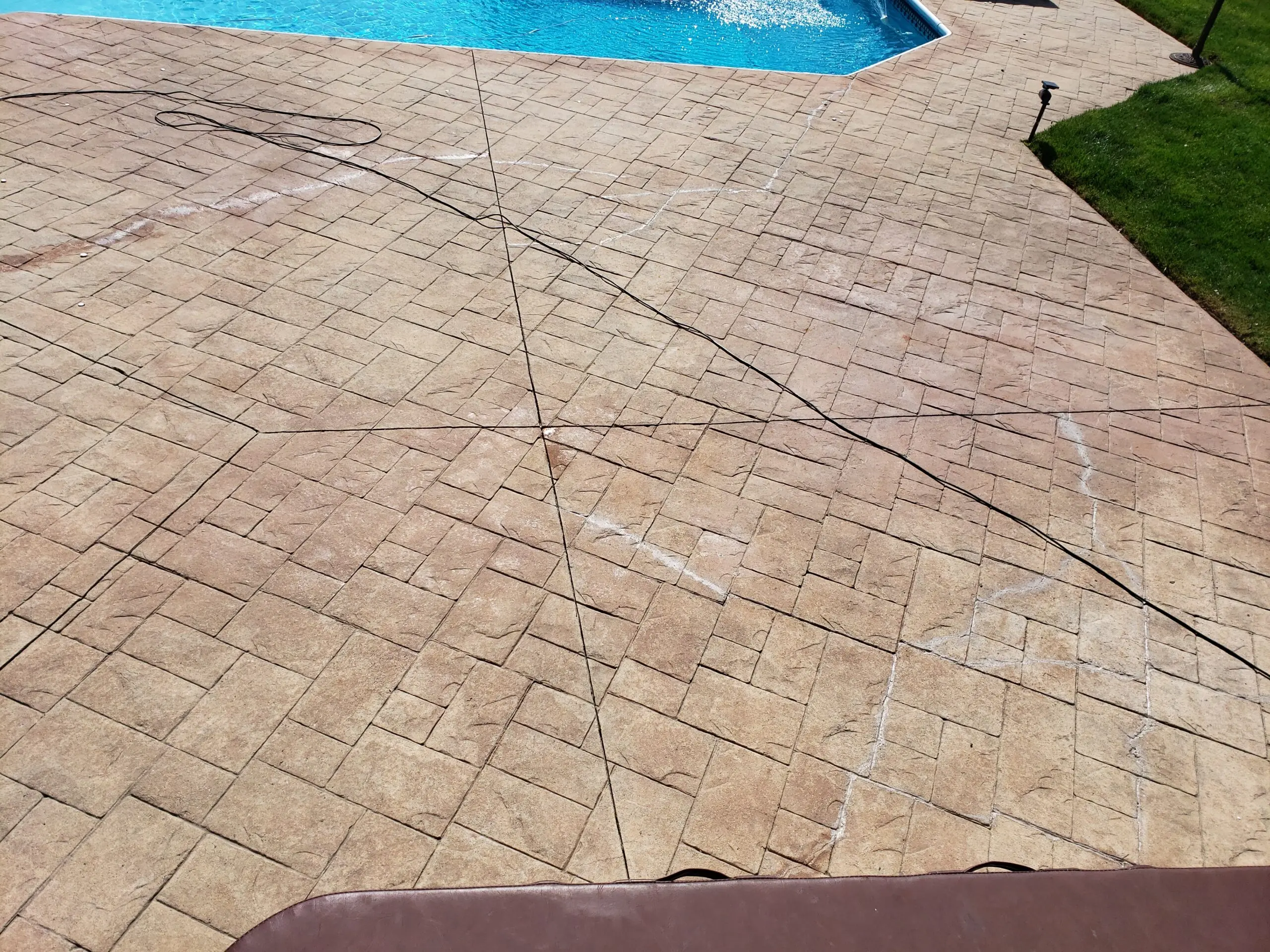 Pre-transformation photo of the stamped concrete pool deck, last stained 10 years ago