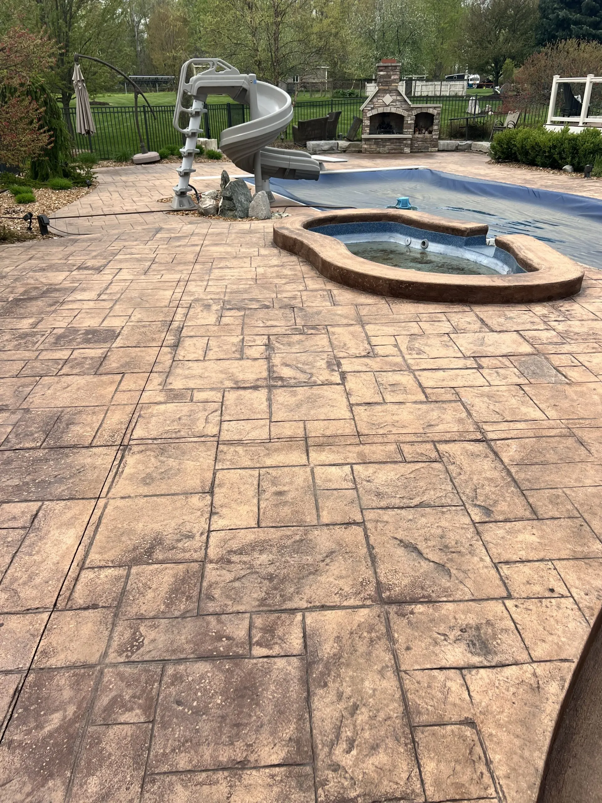 A faded stamped concrete deck, showing signs of wear and weathering